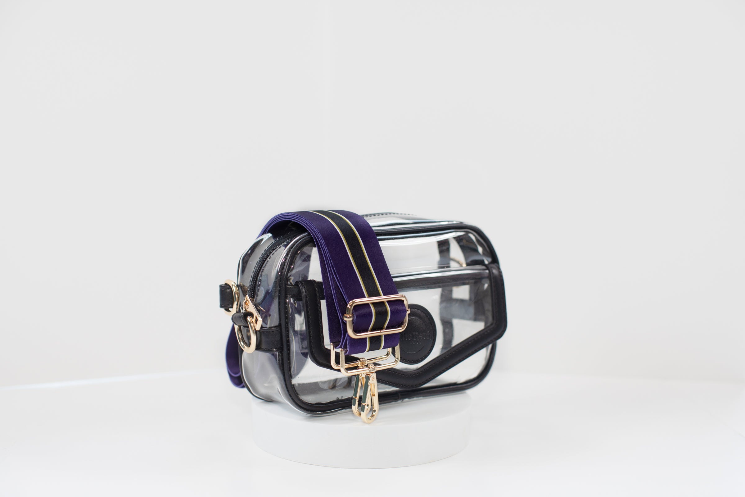 Clear stadium bag with black leather trim, front facing, with a crossbody strap in team colors of the Baltimore Ravens.