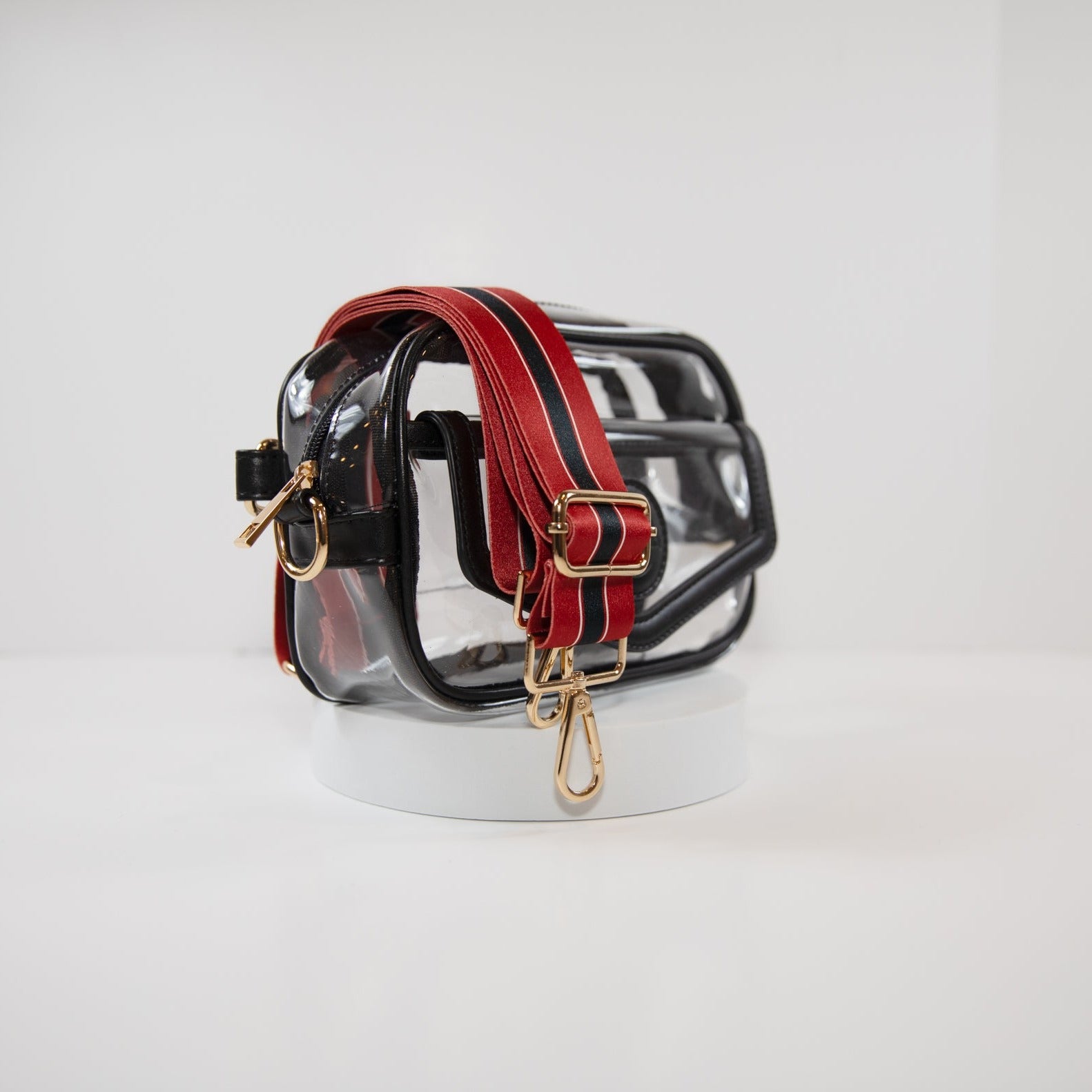 Clear stadium bag with black leather trim, side facing, with a crossbody strap in Houston Texan team colors.